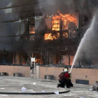 Un bombero intenta apagar el fuego de un edificio del complejo de la alcaldía de Chilpancingo.-Foto: AFP / YURI CORTEZ