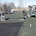 La empresa encargada de las obras en los Anexos levanta ayer la hierba artificial del segundo campo.-J. M. LOSTAU