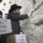 Un rabino deja cartas destinadas a Dios en el Muro de las Lamentaciones en Jerusalén.-/ AFP / MENAHEM KAHANA