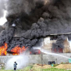 Los bomberos tratan de apagar el fuego declarado en una fábrica de zapatos de Manila.-Foto: AFP