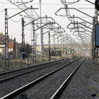 Un joven atraviesa las vías del tren a su paso por la ciudad por un lugar no autorizado.-PABLO REQUEJO
