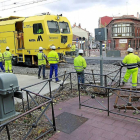 Operarios junto a la máquina niveladora de vías, ayer, en el paso a nivel de Pilarica temporalmente cerrado-J.M. Lostau