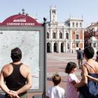 Una familia de turistas observa el panel informativo de las rutas 'Caminar es bueno' en la Plaza Mayor de Valladolid-Ical