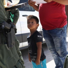 Un niño y sus padres, procedentes de Honduras, son retenidos por una patrulla policial cerca de la frontera de EEUU con México en Misión (Tejas), el 12 de junio pasado.-JOHN MOORE