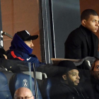 MBappé, abrigado, siguiendo el último partido del PSG, junto a Dani Alvés, en el Parque de los Príncipes.-AFP