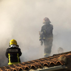 Un grupo de bomberos trabaja en el tejado de la vivienda.-ICAL
