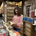 Una lectora ojea una volumen en la Librería Sandoval de Valladolid. | E. M.