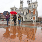 Tres mujeres caminan bajo sus paraguas ayer en la Plaza Mayor de Valladolid .-M.A.S