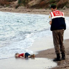 El niño sirio Aylan Kurdi, ante un guardacostas en la playa de Turquía a la que llegó su cadáver.-REUTERS / NILUFER DEMIR