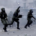 Policías lanzan botes de gas lacrimógeno contra los manifestantes que les lanzaron piedras y latas en las inmediaciones del Congreso, en Buenos Aires, el 14 de diciembre.-AP