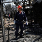Un bombero inspecciona una de las viviendas quemadas por las llamas en la ciudad de Mati, próxima a Atenas.-ALKIS KONSTANTINIDIS (REUTERS)