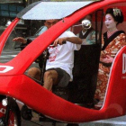 Una geisha se desplaza en un taxi triciclo por Kioto.-ISAO MORISHITA (AP)