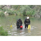 Dos efectivos del GEAS de la Guardia Civil inspeccionan el río con el objetivo de localizar el cuerpo del joven.-GC