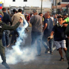 Un militar lanza un bote de gas lacrimógeno durante los disturbios en Caracas-CARLOS GARCIA RAWLINS (REUTERS)