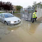 Un coche sale del centro de salud de Renedo por una vía inundada después de la tormenta.-J.M. LOSTAU