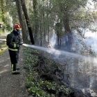 Los Bomberos sofocan el incendio de rastrojos y pinos en el camino de La Farola de Laguna de Duero.-J. M. LOSTAU