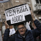 Uno de los participantes en la manifestación contra la despoblación del casco antiguo y el aumento descontrolado del turismo en Venecia.-AFP / MARCO BERTORELLO