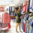 Una joven formada con los proyectos de La Caixa trabaja en una tienda de ropa.-ICAL