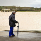 Un hombre observa la inundación de los campos de Mayorga, provocada por el río Cea.-ICAL