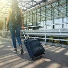 Una joven lleva su maleta en un aeropuerto.- E.M.