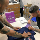 Antonio Domínguez firma la manga de la camiseta de un aficionado.-EL MUNDO