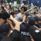 Un grupo de personas intentan romper la barrera formada por la policia durante una protesta en Polonia-BARTLOMIEJ ZBOROWSKI