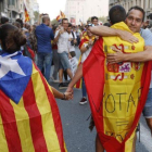 En la imagen una pareja con estelada y bandera española es abrazada por un independentista en Ronda Universitat.-JULIO CARBO