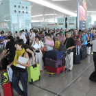 Pasajeros hacen cola para facturar las maletas que no pueden embarcar como equipaje de mano, en el aeropuerto de El Prat.-Foto: DAVID NOGUERA