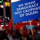 Un hombre sostiene un cartel junto a otros reunidos noche tras noche desde el 15 de julio, día del intento de golpe de Estado, en Ankara, el 27 de julio.-REUTERS / UMIT BEKTAS