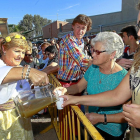 Una ‘lagarera’ sirve el primer mosto del año a algunos visitantes de la Fiesta de la Vendimia, ayer en Serrada.-J.M.LOSTAU