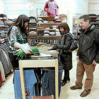 Un hombre y una mujer eligen la ropa ante los consejos de la dependienta en un comercio textil de la calle Mantería-J.M.Lostau