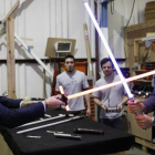 Los príncipes Enrique y Guillermo juegan con las espadas de luz de Star Wars en su visita a los estudios de Londres donde se está rodando la octava entrega de la saga.-EL PERIÓDICO (AP / ADRIAN DENNIS)