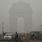 Turistas visitan la Puerta de la India bajo una fuerte niebla de polución en Nueva Deli.-SAJJAD HUSSAIN (AFP)
