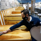 Un trabajador limpia las mesas del interior del restaurante La Mejillonera. | J.M. LOSTAU