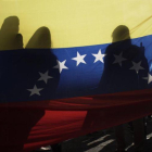 La bandera venezolana, entre sombras en una protesta en Costa Rica.-EFE/JEFFREY ARGUEDAS