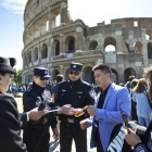 Dos agentes chinos, junto a dos italianos, revisan la documentación de un grupo de turistas chinos, en el exterior del Coliseo, en Roma, este lunes.-AP / JIN YU