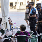 Dos agentes de la Policía indican a usuarios de las terrazas de la Plaza Mayor que deben llevar mascarilla . - R. G: PABLO REQUEJO (PHOTOGENIC)