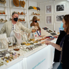 Una visitante de la Feria de Artesanía se interesa por los objetos expuestos en la Acera de Recoletos. / J.M. LOSTAU