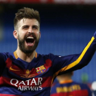 Piqué, con un trozo de red cortada de la portería del Calderón, festeja la Copa.-AP / FRANCISCO SECO