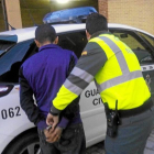 Un agente de la Guardia Civil con el detenido junto al coche que iba a conducirle al Puesto de Almazán en la tarde del martes-Ical