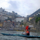 Paso de un turista en kayak por la ciudad portuguesa de  Oporto.-J.L.C.