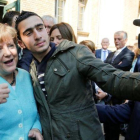 El refugiado sirio Anas M. se hace un selfie con Merkel, en septiembre del 2015.-REUTERS / FABRIZIO BENSCH