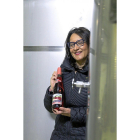 Inés Salas posa con una botella de Piña Picota entre dos depósitos de elaboración.-M.T.