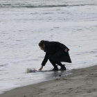 Mark Kanekita, de 37 años, lanza flores al mar en memoria de las víctimas del terremoto y posterior tsunami de hace cinco años en el distrito de Abraham en Sendai (Japón).-KIMIMASA MAYAMA / EFE