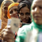Varias mujeres hacen cola en un colegio electoral durante la segunda fase de las elecciones para la Asamblea estatal de Gujarat, en Ahmedabad (India), el 14 de diciembre.-EFE