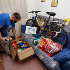 Diego Reglero, presidente de la ONG,  muestra en su casa el material solidario, entre ello una bicicleta y muchos kilos de alimentos. J.M. LOSTAU