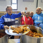 Reparto de las salchichas típicas de Zaratán, ayer en el pabellón deportivo, tras finalizar la Carrera Popular.-MIGUEL ÁNGEL SANTOS / PHOTOGENIC