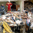 Los operarios trabajan en el edificio destrozado tras la explosión del año 2007.-ICAL