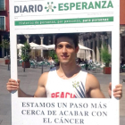 El becario Enrique Pérez  sostiene el cartón  de la campaña de recogida que apoya la lucha contra el cáncer de la AECC-EL MUNDO