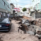 Un vehiculo permanece atrapado entre el lodo en una calle destruida tras el fuerte terremoto.-EFE